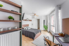 Étagères déco, lit et bureau près de la fenêtre
