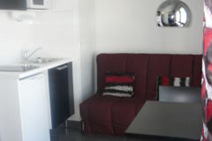 Séjour avec coin cuisine équipé clic clac table chaises